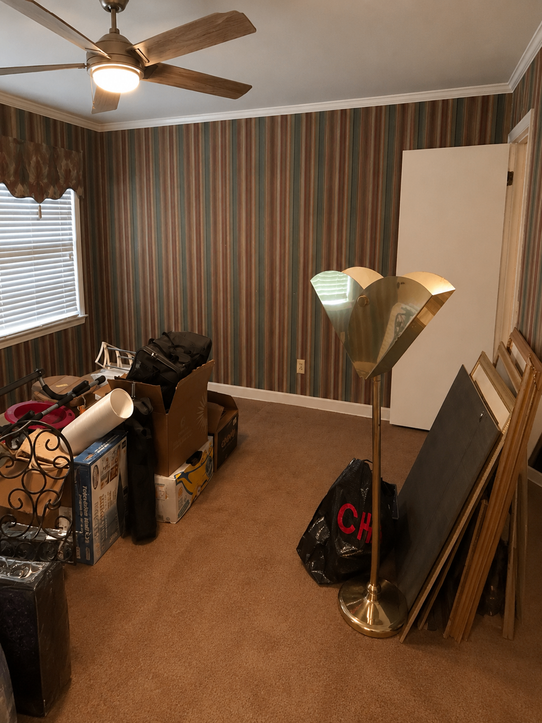 Bedroom with dated striped wallpaper before removal