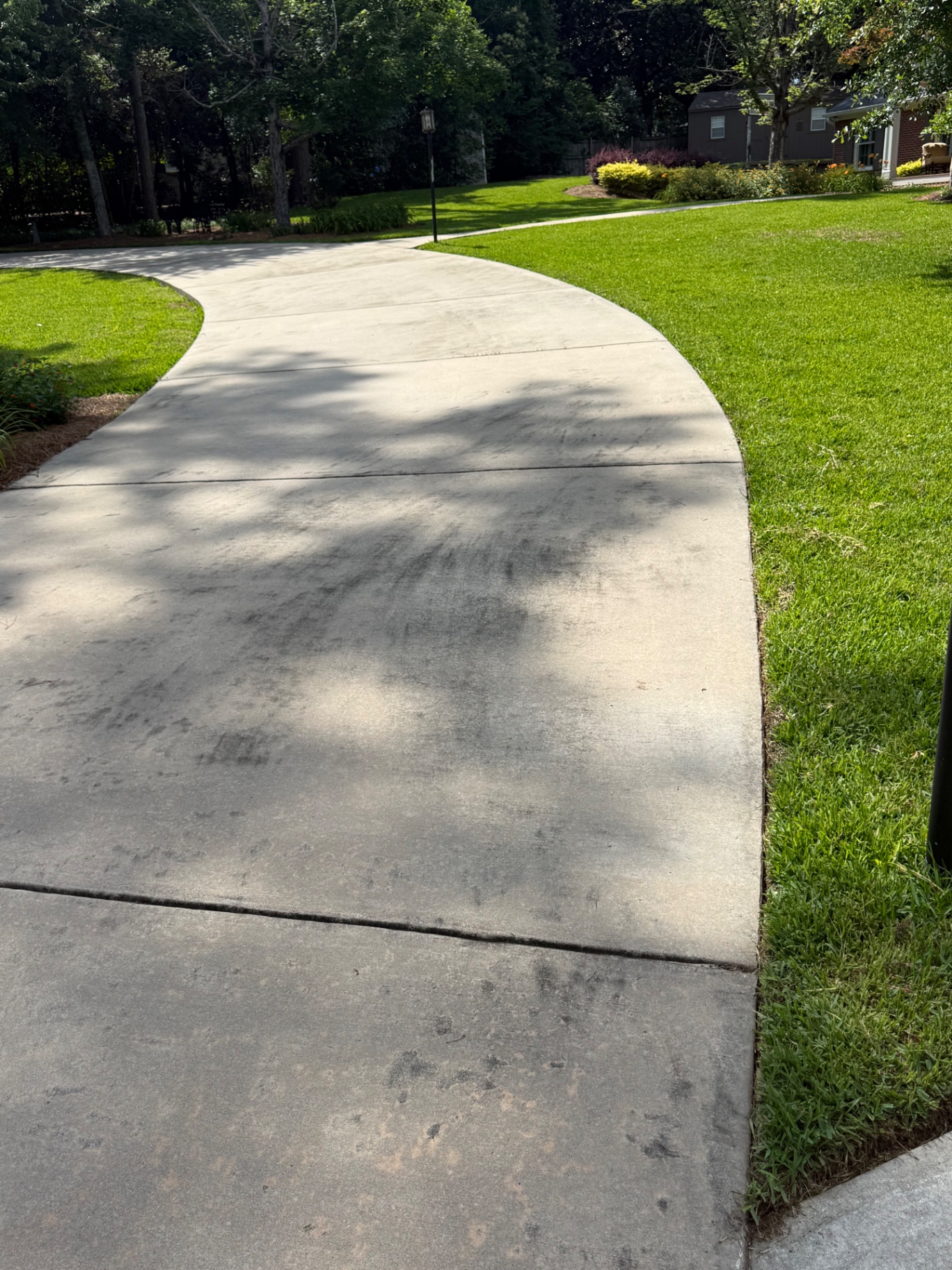 Curved residential driveway after lawn edging along the lawn line